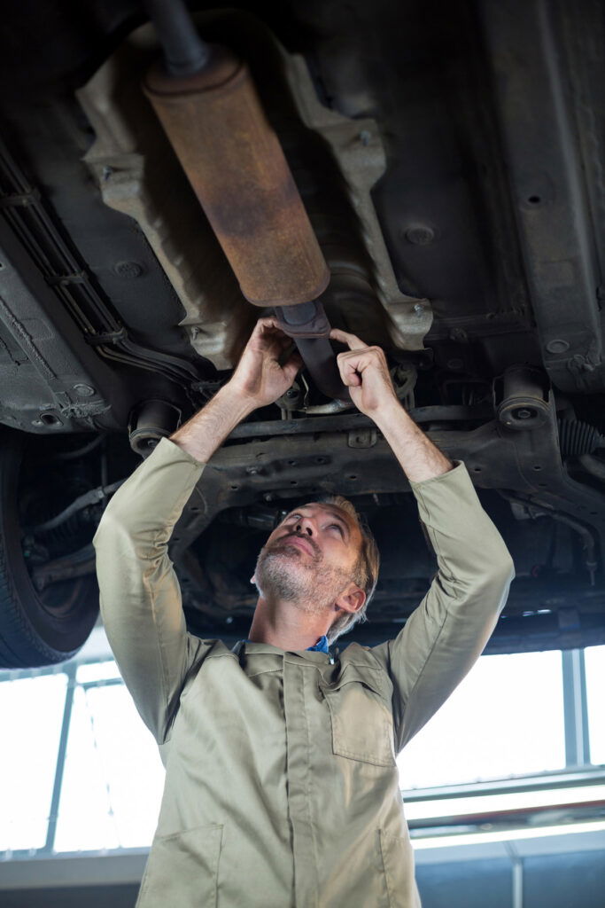 Mechanic repairing a car muffler